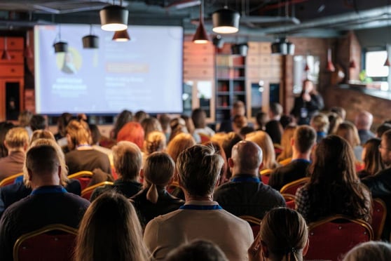 Audience gathered in a conference setting.