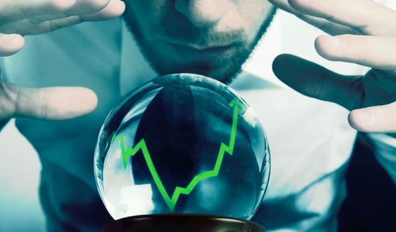 Man looking at a crystal ball with a graph climbing up.