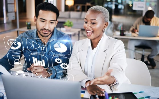 Business man abd woman with a laptop using a hologram dashboard.