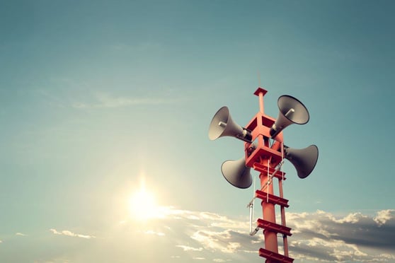 Horn speaker for alerts, sun with blue sky background.